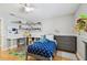 Bright bedroom featuring hardwood floors, a ceiling fan, and custom shelving for displaying collectibles at 2506 S Obrapia St, Tampa, FL 33629