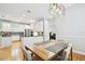Bright dining room with modern chandelier, wood table and chairs with kitchen in background at 2506 S Obrapia St, Tampa, FL 33629