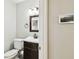 Clean half-bathroom featuring a modern vanity, toilet, and decorative mirror at 2506 S Obrapia St, Tampa, FL 33629
