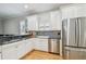 Well-designed kitchen features stainless steel appliances and white cabinets with seating area at 2506 S Obrapia St, Tampa, FL 33629