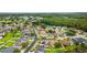 Aerial view of a lush residential neighborhood with mature trees, green lawns, and access to a beautiful community lake at 25946 Buckthorn Ave, Land O Lakes, FL 34639