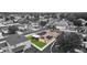 A high-angle aerial view of a home, showing a well maintained green lawn, a screened patio, and roof-mounted solar panels at 25946 Buckthorn Ave, Land O Lakes, FL 34639
