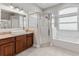 Bright bathroom featuring a walk-in shower, granite countertops, and a soaking tub under a large window at 25946 Buckthorn Ave, Land O Lakes, FL 34639