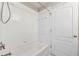 Clean, well-lit bathtub/shower with white tiles, and a door at 25946 Buckthorn Ave, Land O Lakes, FL 34639