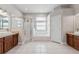 Bright bathroom featuring dual vanities, a soaking tub, and a glass-enclosed shower at 25946 Buckthorn Ave, Land O Lakes, FL 34639