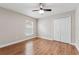 Bedroom featuring wood floors, a window, ceiling fan, and double door closet, a serene retreat at 25946 Buckthorn Ave, Land O Lakes, FL 34639