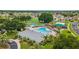 Aerial view of a resort-style community pool with lounge chairs, lush landscaping, playground, and sports courts at 25946 Buckthorn Ave, Land O Lakes, FL 34639