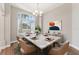 Elegant dining room with marble-top table, stylish chairs, chandelier, and large window at 25946 Buckthorn Ave, Land O Lakes, FL 34639