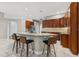 Kitchen featuring a large island with seating, granite countertops, dark wood cabinetry, and stainless steel appliances at 25946 Buckthorn Ave, Land O Lakes, FL 34639