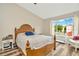 Bright bedroom featuring a large bed, hardwood floors, and a large window offering natural light and views at 267 Countryside Key Blvd, Oldsmar, FL 34677