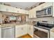 Modern kitchen featuring stainless steel appliances, granite countertops, and white cabinetry with lots of storage at 267 Countryside Key Blvd, Oldsmar, FL 34677