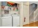 Functional laundry area with a washer, dryer, and shelving for storage, conveniently located near the staircase at 267 Countryside Key Blvd, Oldsmar, FL 34677
