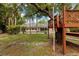 A spacious backyard featuring a screened pool enclosure and a wooden treehouse at 3108 S Omar Ave, Tampa, FL 33629