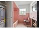 A partially renovated bathroom with pink tile, a tub, and a toilet at 3108 S Omar Ave, Tampa, FL 33629