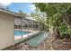 Partially obscured pool area featuring an adjacent structure that has access to both the pool and backyard at 3108 S Omar Ave, Tampa, FL 33629