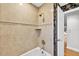 Elegant bathroom with beige tile surround, gold fixtures, and a white door at 3269 Nicks Pl, Clearwater, FL 33761