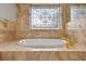 Tranquil bathroom showcasing a standalone soaking tub with decorative tiled walls and stained-glass window at 3269 Nicks Pl, Clearwater, FL 33761