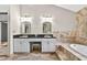 Elegant bathroom featuring double sink vanity, black granite countertop, and a luxurious soaking tub at 3269 Nicks Pl, Clearwater, FL 33761