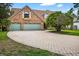 Charming brick home featuring a paved driveway and well manicured lawn under a sunny sky at 3269 Nicks Pl, Clearwater, FL 33761