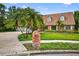 Charming brick home featuring a paved driveway and well manicured lawn under a sunny sky at 3269 Nicks Pl, Clearwater, FL 33761