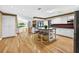 Open kitchen featuring an island with seating, white cabinetry, and wood flooring at 3269 Nicks Pl, Clearwater, FL 33761