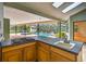 Outdoor kitchen featuring a built-in cooktop overlooking a sparkling pool at 3269 Nicks Pl, Clearwater, FL 33761