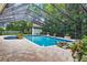 Inviting pool with stone accents and lush landscaping, set within a screened enclosure at 3269 Nicks Pl, Clearwater, FL 33761