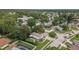 Aerial view of a well-maintained single-Gathering home with mature landscaping, a screened-in lanai, and a two car garage at 3501 Sarazen Dr, New Port Richey, FL 34655