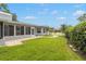 Well-maintained backyard features lush grass, a brick pathway, and a screened-in lanai, perfect for outdoor enjoyment at 3501 Sarazen Dr, New Port Richey, FL 34655