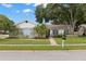 Charming single-story home with well-manicured lawn, mature trees and landscaping with a brick walkway leading to the front door at 3501 Sarazen Dr, New Port Richey, FL 34655