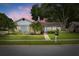 Charming single-story home with well-manicured lawn, mature trees and landscaping with a brick walkway leading to the front door at 3501 Sarazen Dr, New Port Richey, FL 34655