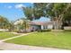 Single-story home with lush front lawn and manicured landscaping with a brick walkway leading to the front door at 3501 Sarazen Dr, New Port Richey, FL 34655