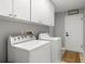 Bright laundry room with washer, dryer, and plenty of cabinet space at 3501 Sarazen Dr, New Port Richey, FL 34655
