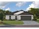 Charming single-story home with a well-manicured lawn and an attached two-car garage, under a cloudy blue sky at 36915 Sagemoor Dr, Zephyrhills, FL 33541