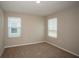 Bedroom with two windows and neutral carpeting, creating a cozy and inviting atmosphere at 36933 Sagemoor Dr, Zephyrhills, FL 33541