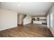 Open concept living area features modern wood flooring, a staircase, and views into the kitchen at 36933 Sagemoor Dr, Zephyrhills, FL 33541