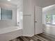 Bathroom featuring a tub, a window, and wood look flooring at 4129 Marlow Loop, Land O Lakes, FL 34639