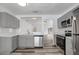 Updated kitchen with gray cabinets, stainless appliances, and breakfast bar overlooking the living area at 4129 Marlow Loop, Land O Lakes, FL 34639