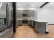 Modern kitchen featuring gray cabinets, stainless steel appliances, stylish backsplash, and wood floors at 4148 Gauge Line Loop, Tampa, FL 33624