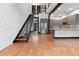 Spacious living room featuring a staircase, modern kitchen with stainless steel appliances, and wood floors at 4148 Gauge Line Loop, Tampa, FL 33624
