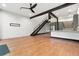 Open-concept living room with white brick wall, staircase, and modern kitchen with stainless steel appliances at 4148 Gauge Line Loop, Tampa, FL 33624