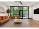Bright living room with hardwood floors, a ceiling fan, and large windows overlooking greenery at 4148 Gauge Line Loop, Tampa, FL 33624