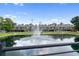 Community pond view with fountain and modern townhome complex at 4148 Gauge Line Loop, Tampa, FL 33624
