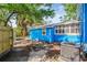 Backyard of the blue house featuring an AC unit and surrounded by a wooden fence and tall trees at 4411 3Rd S Ave, St Petersburg, FL 33711