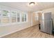 Bright sunroom features wood-look flooring, white paneled ceiling, and a stainless steel refrigerator at 4411 3Rd S Ave, St Petersburg, FL 33711