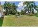 Large backyard with lush green grass, mature trees, and trampoline at 5206 Cindy Kay Dr, Plant City, FL 33566