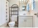 Bright bathroom with white tile, modern vanity, and black metal shelving for storage at 5206 Cindy Kay Dr, Plant City, FL 33566