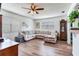 Spacious living room with a large sectional sofa, ceiling fan, and wooden floors, perfect for relaxing and entertaining guests at 5206 Cindy Kay Dr, Plant City, FL 33566
