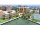 An aerial shot of buildings near the beach with tennis courts and a community pool at 5353 Gulf Blvd # A402, St Pete Beach, FL 33706