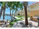 A lovely backyard with a view of the water, picnic bench, grill, and grassy area at 5353 Gulf Blvd # A402, St Pete Beach, FL 33706